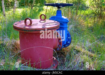 Ausbau Altleitung Getränk Wasserleitungen mit neuen blauen Ventil und neue blaue gemeinsame Mitglieder beigetreten. Neue Ablassventil. Metall korrodiert Textur. Stockfoto