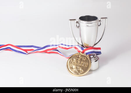 Erster Platz Goldmedaille und Silber Pokal der Pokalsieger umschlungen zusammen auf einem grauen Hintergrund mit Textfreiraum Stockfoto