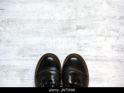 Mann in schwarzen Schuhen stehen auf weißen Boden Hintergrund Stockfoto