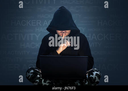Mann mit verborgene Seite, die Arbeit am Computer. Halten einen Finger an den Mund. Computer-Hacker stehlen Daten von einem Laptop-Konzept für die Netzwerksicherheit, ich Stockfoto