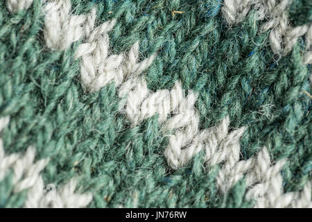 Eine schöne Nahaufnahme von einer Hand gestrickte warme und weiche Wolle Muster. Weiche Socken oder Schal aus Naturwolle. Bunte Muster. Stockfoto