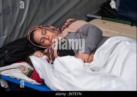 Polizist mit einem jungen syrischen Flüchtlinge Junge am Registration Center in Passau, Deutschland. Der Offizier spricht mit den kleinen Jungen. Stockfoto