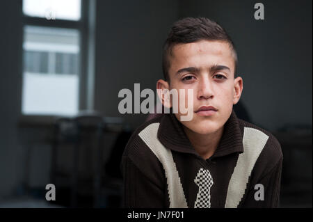 Polizist mit einem jungen syrischen Flüchtlinge Junge am Registration Center in Passau, Deutschland. Der Offizier spricht mit den kleinen Jungen. Stockfoto