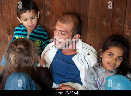 Passau, Deutschland - 2. August 2015: Vater und seine drei jungen Kinder im Flüchtlingslager Registration Center in Passau ankommen, Süddeutschland. Stockfoto