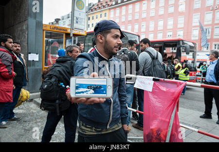 München, Deutschland - 7. September 2015: Flüchtling aus Afghanistan zeigt Bilder von seinen Urlaub auf einem Boot. Viele Flüchtlinge über das Meer nach Europa fliehen Stockfoto