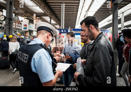 München, Deutschland - 22. September 2015: Flüchtlinge am Bahnhof in München ankommen. Die Polizei kontrolliert die ankommenden Fluechtlinge bei der Registrierung. Stockfoto