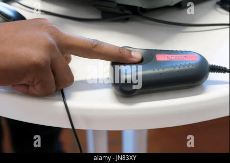 Passau, Deutschland - August 1th, 2015: ein Polizist ist der Fingerabdruck eines Menschen bei der Anmeldung Zentrum für Flüchtlinge in Passau, Deutschland. Stockfoto