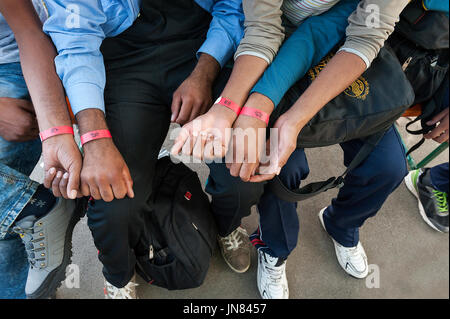 Passau, Deutschland - August 1th, 2015: Eintragung der jungen Flüchtlinge in einem Flüchtlingslager in Passau, Deutschland. Leute empfangen Armbänder für die Identifikation. Stockfoto