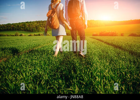 Junges Paar wird durch die Greenfield bummeln. Frau und Mann halten einander die Hände. Stockfoto