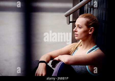 Eine junge Frau nimmt eine Auszeit vom Training in der Stadt Stockfoto