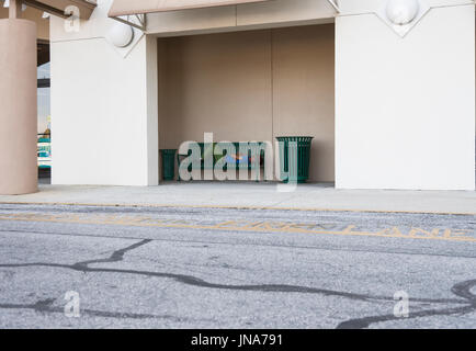 Obdachloser schlafen auf grünen Eisen Bank in Leesburg, Florida USA Stockfoto