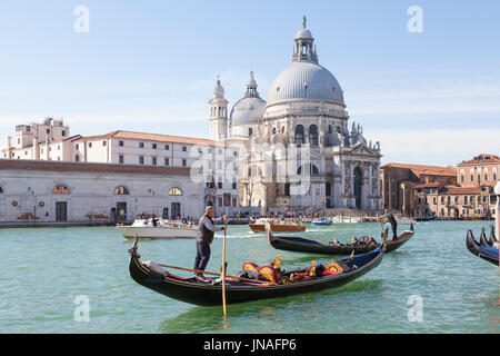 März 2017 Canal Grande, Venedig, Italien. Zwei Gondolieri Rudern ihre Gondeln letzten taxis der Basilika Santa Maria della Salute mit Wasser kreuzen auf Stockfoto