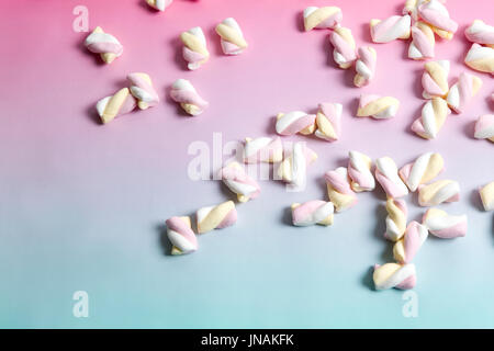 Regenbogen Marshmallow Multi farbige Süßigkeiten Süßigkeiten auf einem Farbverlauf Hintergrund rosa und blau. Minimale Farbe Still Life Fotografie Stockfoto