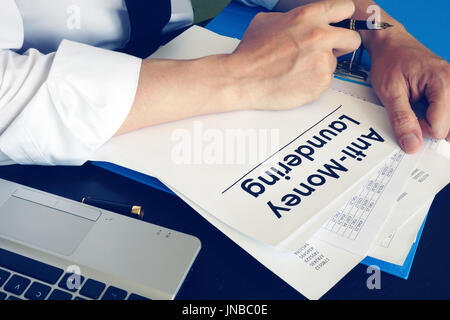 Der Mensch ist mit der Geldwäsche AML. Stockfoto