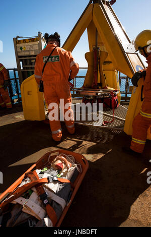 Ein Sanitäter mit orangefarbenen Overalls/Overalls, Dummy Unfall auf einer Bahre in den Frosch geladen werden. Quelle: LEE RAMSDEN/ALAMY Stockfoto