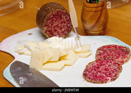 Heimatpartei Vorspeise - Gourmet-Käse und Salami auf weiß gut genutzt, Schneidebrett Stockfoto