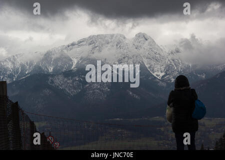 Frau auf der Suche auf Giewont Gipfel in Wolken im winter Stockfoto