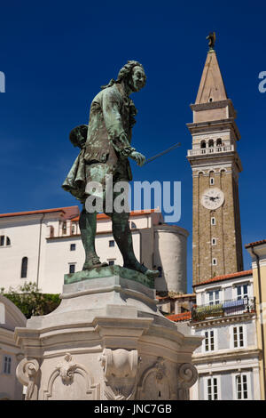 Nahaufnahme von Geiger Giuseppe Tartini Statue in Slowenien Piran Tartini Platz mit St George Parish Kirche und der Glockenturm Uhrturm am blauen Himmel Stockfoto