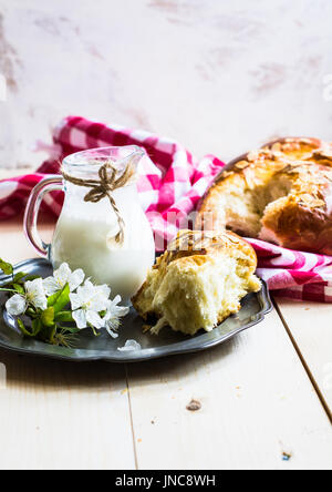 Frisch gebackene geflochtene Brot mit Mandeln und Milch auf rustikalen Tisch Stockfoto