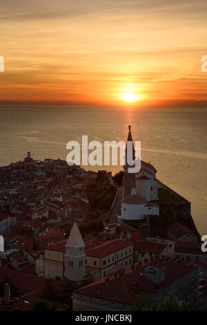 Untergehende Sonne an der Adria hinter Erzengel Michael auf Glockenturm der St.-Georgs-Kathedrale von Piran Slowenien Stockfoto