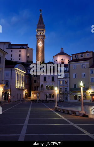 Tartini-Platz in Piran Slowenien mit St George katholische Pfarrkirche mit Glockenturm und Baptisterium, venezianischen Haus in der Dämmerung Abenddämmerung Stockfoto