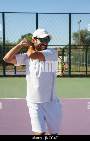 Profi-Tennisspielerin mit Gesicht Aufwand einen Tennis-Kick mit dem Schläger auf einem Tennisplatz an einem sonnigen Tag zu tun. Stockfoto