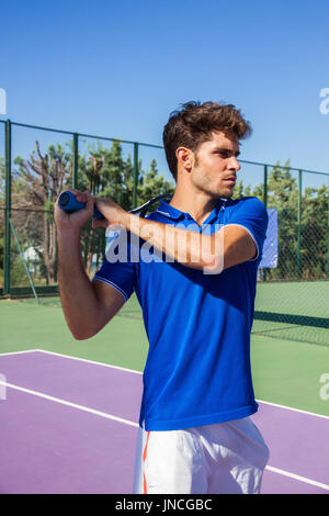 Profi-Tennisspieler tut ein Kick-Tennis auf dem Tennisplatz an einem sonnigen Sommermorgen. Das ist in der Sportswear gekleidet. Stockfoto