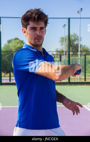 Profi-Tennisspieler tut ein Kick-Tennis auf dem Tennisplatz an einem sonnigen Sommermorgen. Das ist in der Sportswear gekleidet. Stockfoto