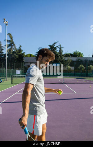 Profi-Tennisspieler ist ein Kick-Tennis auf dem Tennisplatz an einem sonnigen Morgen tun. Stockfoto