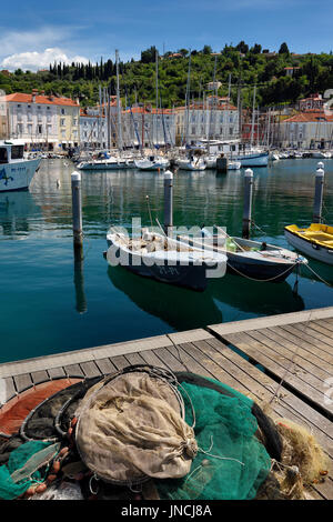 Fischernetze am Dock von Piran Slowenien mit Boote und Segelboote vor Anker im Hafen an der Adria-Küste Stockfoto