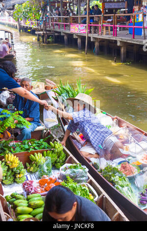 Thai Frau in einem Boot, die Zahlung vom Kunden am Khlong Lat Mayom Floating Market, Bangkok Thailand Stockfoto