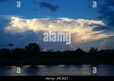 Quiet Waters Park See in der Abenddämmerung mit weißen Wolken oberhalb der Waldgrenze in der Ferne Stockfoto