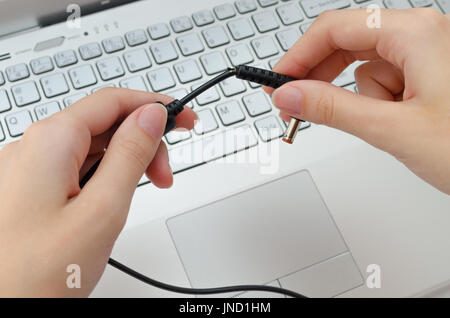 Defekte Kabel vom Laptop Ladegerät in Händen Stockfoto