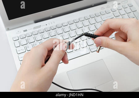 Defekte Kabel vom Laptop Ladegerät in Menschenhand Stockfoto