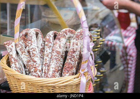 Nahaufnahme der Weidenkorb mit typisch italienischer Salami auf dem Markt, traditionelle Köstlichkeiten. Realen Szene im Markt. Stockfoto