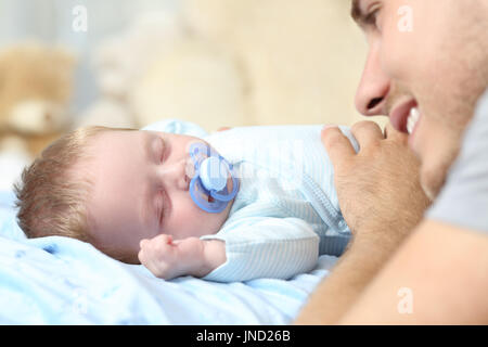 Porträt eines Vaters auf ihr Baby schlafen im Bett beobachten hautnah Stockfoto