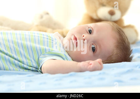 Porträt eines Babys auf einem Bett liegend und mit Blick auf Sie Stockfoto