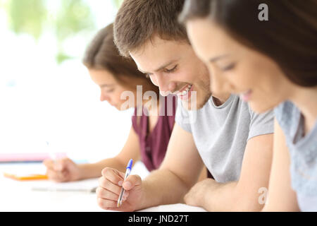 Nahaufnahme eines glücklichen Studenten Notizen in einem Klassenzimmer Stockfoto