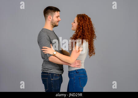 Ein schönes junges Paar von Angesicht zu Angesicht stehen und halten einander die Hände Stockfoto