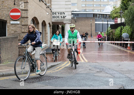 London, UK. 29. Juli 2017. Reiten auf dem Bürgersteig in der Nähe von St Katharine Docks Radfahrer gelten, eine Barriere am Tag der Fahrt London-Radsport-Event übergeben. Bildnachweis: Vickie Flores/Alamy Live-Nachrichten Stockfoto
