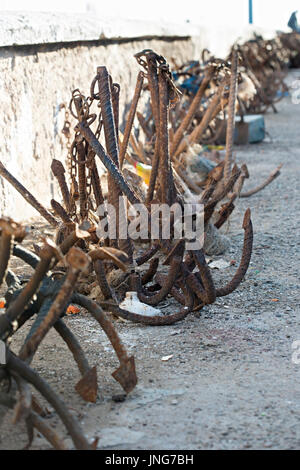 Ein Haufen rostigen Anker Haken an der konkreten Steg des Fischereihafens von Essaouira, Marokko. Stockfoto