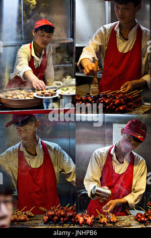 Niedlichen chinesischen Verkäufer würzen Fleisch am Spieß auf traditionellen Lebensmittelmarkt. Wangfujing, Chaoyang District, Beijing, China, 5. April 2016 Stockfoto