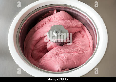 Hausgemachtes Himbeer Eis in eine kleine professionelle Eismaschine Buttern. Stockfoto