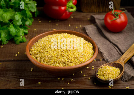 Bulgur Glutenfrei Weizenkörner in Schale auf Holztisch Stockfoto