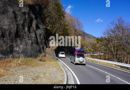 Nikko, Japan - 3. November 2014. Fahrzeuge laufen auf Bergstrasse am sonnigen Tag in Nikko, Japan. Nikko ist eine Stadt am Eingang zum Nikko-Nationalpark, den meisten f Stockfoto