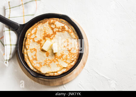Hausgemachte Crepes mit Butter in Gusseisen Pfanne und Zutaten über rustikale weißen Hintergrund - Kochen frische hausgemachte Frühstück Pfannkuchen Pfannkuchen essen Stockfoto