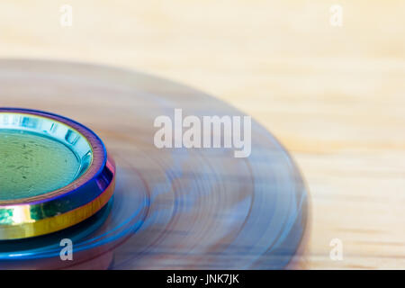 Eine exklusive Fidget Spinner aus Metall wird schnell und liegt auf Holz Stockfoto