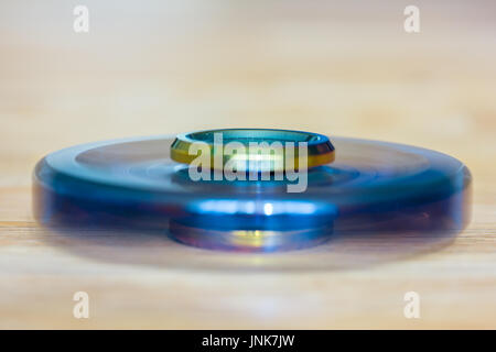 Eine exklusive Fidget Spinner aus Metall wird schnell und liegt auf Holz Stockfoto