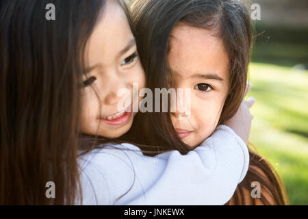 Niedliche kleine Mädchen umarmt. Schwestern und Freundinnen. Stockfoto