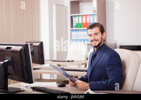 Erfolgreicher Geschäftsmann im Anzug in seinem Büro Stockfoto